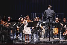 Kleine Violinsolistin mit Orchester