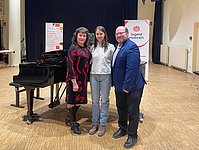 Lehrer Schüler im Konzertsaal vor Flügel