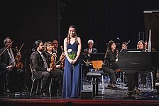 Pianistin nach dem Auftritt mit Blume und Orchester