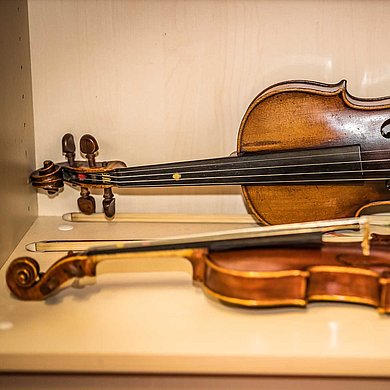 Eine Violine und eine Viola in einer Instrumentenvitrine