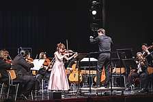 Mädchen an der Violine mit Orchester 